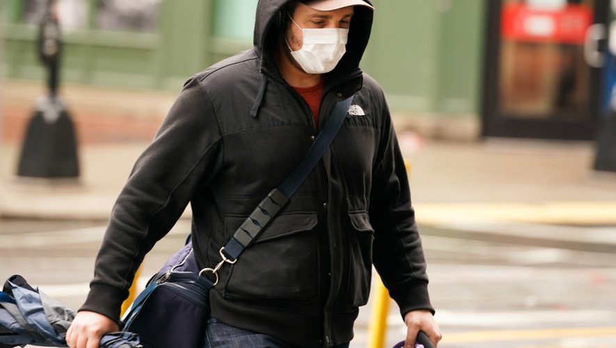 Un piéton portant un masque de protection contre le Coronavirus