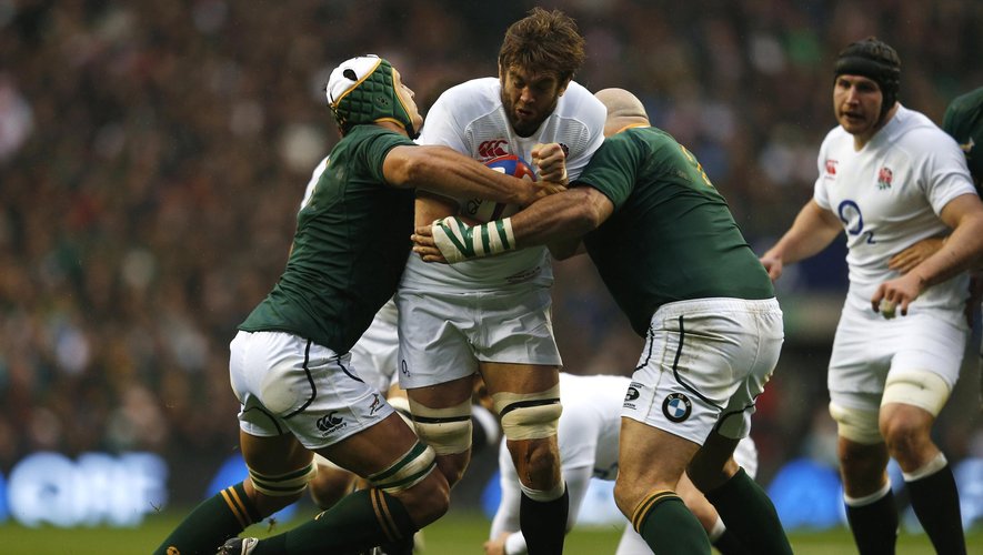 Geoff Parling (C) of England is tackled by Juandre Kruger (L) and Gurthro Steenkamp of South Africa during their international rugby match at Twickenham