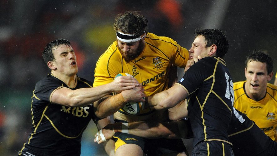 ustralian flanker Scott Higginbotham (C) is tackled by Nick De Luca (L) and Joe Ansbro (R) of Scotland during the rain-soaked Australia v Scotland rugby union international in Newcastle on June 5, 2012