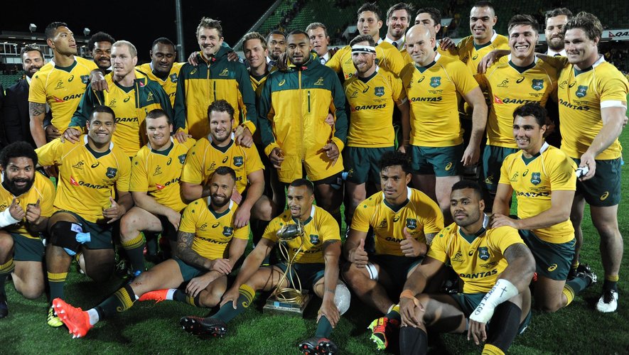 Australian players gather around the trophy after their win in the Rugby Championship match between Australia and Argentina in Perth on September 17, 2016.