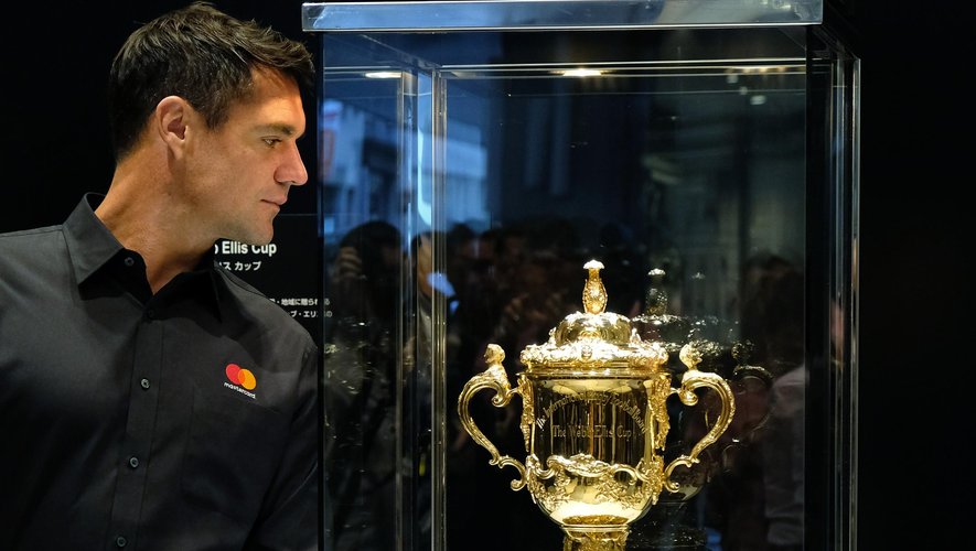 Former All Blacks' player Dan Carter looks at the Webb Ellis Cup, the trophy awarded to the winner of the Rugby World Cup, displayed at a commercial event for the Rugby World Cup 2019 in Tokyo on November 8, 2018.