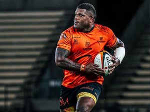 Joueurs de rugby en mêlée lors d'un match de Nationale, avec supporters en arrière-plan