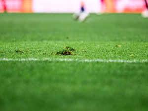 Scène de confrontation sur un terrain de rugby amateur avec arbitre